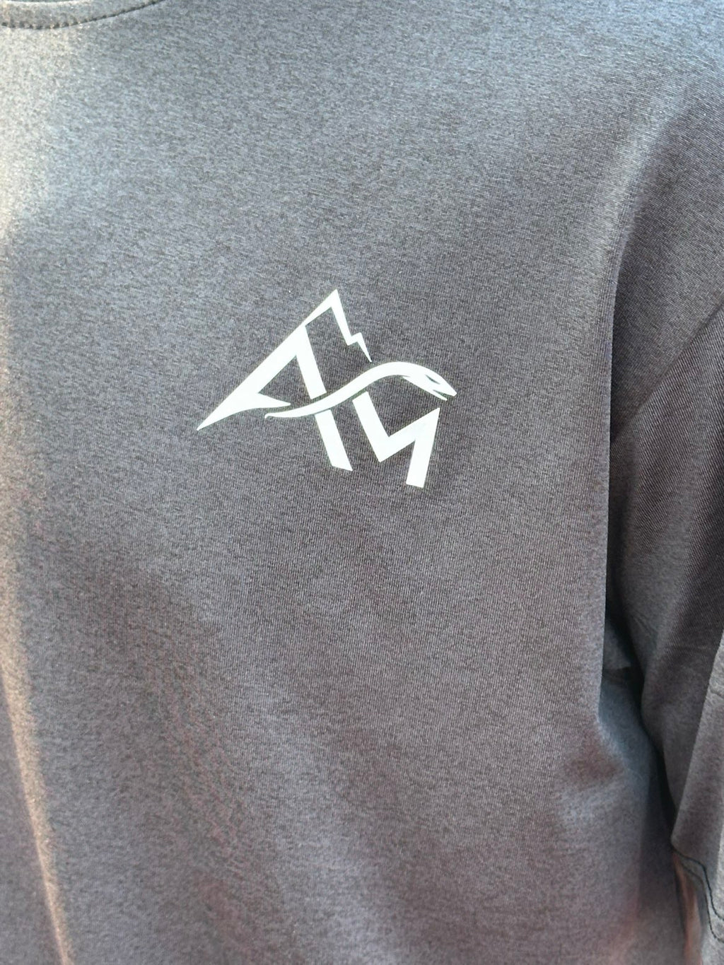 Détail logo brodé AM sur ensemble sport gris Amvora